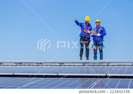 Technicians installing and inspecting standards solar panels on roof industrial factory. Shake hand work success experience. Electrical energy obtained from nature sunlight clean renewable energy. 121632136