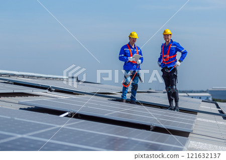 Technicians installing and inspecting standards solar panels on roof industrial factory. Shake hand work success experience. Electrical energy obtained from nature sunlight clean renewable energy. 121632137