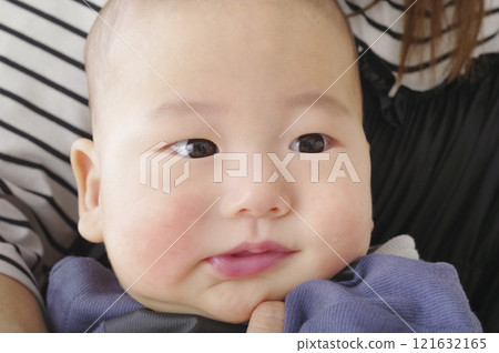 Cute baby being held by mother 121632165