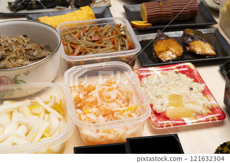 用筷子將禦節料理裝入重箱中。 用筷子將禦節料理裝入重箱中。 121632304