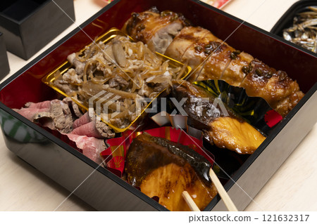 用筷子將禦節料理裝入重箱中。 121632317