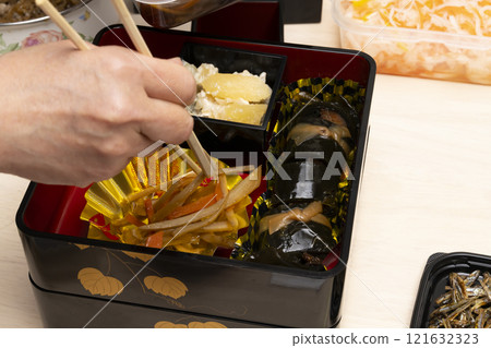用筷子將禦節料理裝入重箱中。 121632323