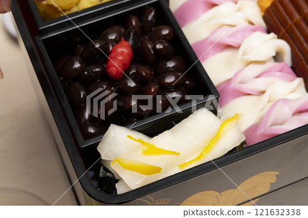 用筷子將禦節料理裝入重箱中。 121632338