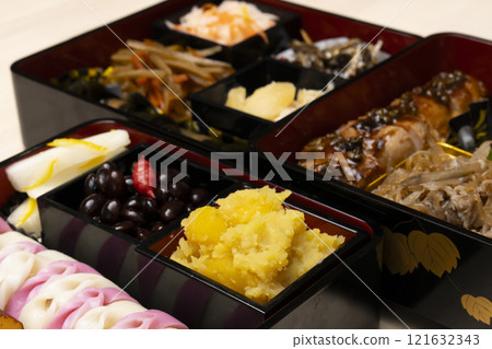 用筷子將禦節料理裝入重箱中。 用筷子將禦節料理裝入重箱中。 121632343