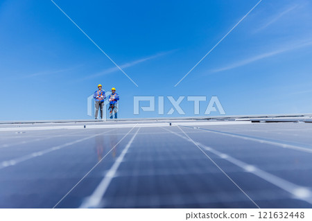 Technicians are installing and inspecting standards of solar panels on roof of an industrial factory. Electrical energy obtained from nature sunlight clean renewable energy. Technicians are installing and inspecting standards of solar panels on roof of an industrial factory. Electrical energy obtained from nature sunlight clean renewable energy. 121632448