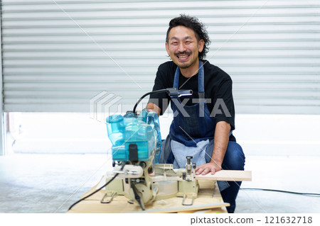 Portrait of a craftsman using an electric saw 121632718