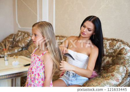 Young Girl Receiving a Hairstyle Makeover in Elegant Hair Salon During Bright Daytime 121633445