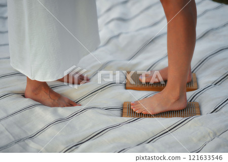 Two people using textured mats for foot therapy outdoors Two people using textured mats for foot therapy outdoors 121633546