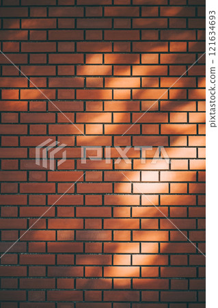 陽光透過樹木照亮的磚牆 陽光透過樹木照亮的磚牆 121634693