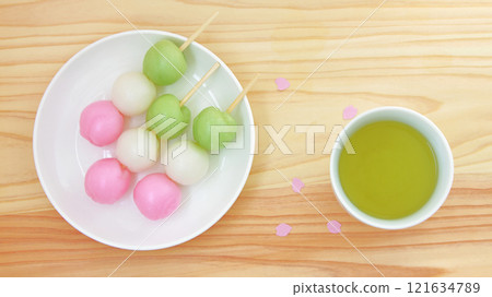 三色團子和綠茶的鳥瞰圖，以及櫻花花瓣散落的春天櫻花觀賞圖像。 121634789