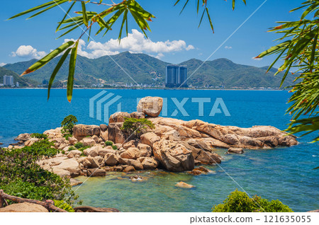 Large rocks on the background of the beach, mountains and high-rise buildings in Nha Trang. Hon Chong cape rock garden Large rocks on the background of the beach, mountains and high-rise buildings in Nha Trang. Hon Chong cape rock garden 121635055