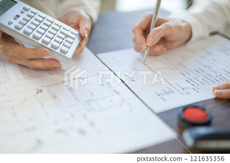 The hands of two women signing a real estate contract The hands of two women signing a real estate contract 121635356