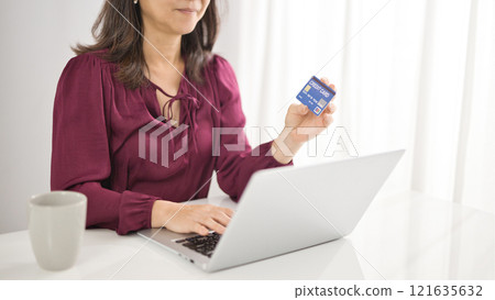 Middle-aged woman shopping online on a computer 121635632