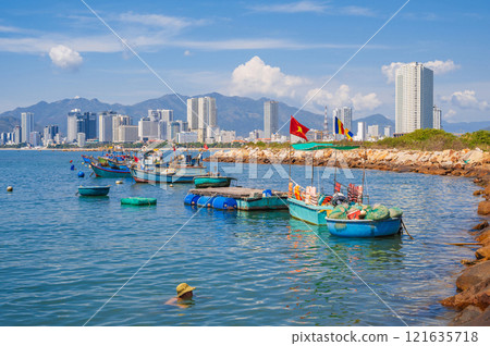 View from the sea of fishing boats and the Vietnamese city of Nha Trang on a sunny cloudy day 121635718