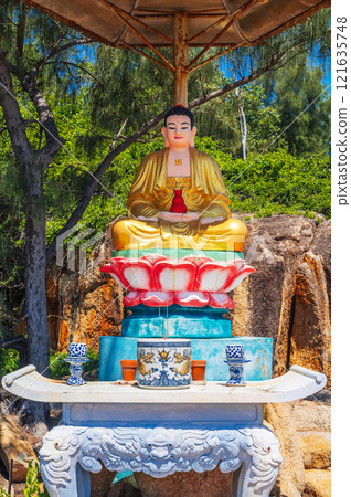 An altar with a sitting Buddha on the territory of a Buddhist temple in Asia. An altar with a sitting Buddha on the territory of a Buddhist temple in Asia. 121635748