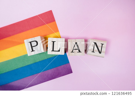 Rainbow flag and a wooden block with the word plan written on it 121636495