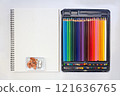 Creative Workspace with Colored Pencils Set and Blank Sketchbook 121636765