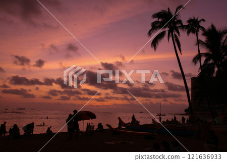 People playing on the beach at sunset 121636933