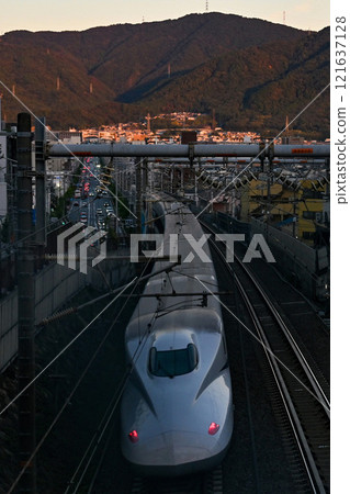 [京都]新幹線在傍晚的陽光下穿過城市 121637128