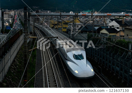 [Kyoto] A Shinkansen train zooming through the city after sunset 121637130