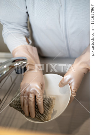 戴著橡膠手套洗碗的女人的手 戴著橡膠手套洗碗的女人的手 121637967