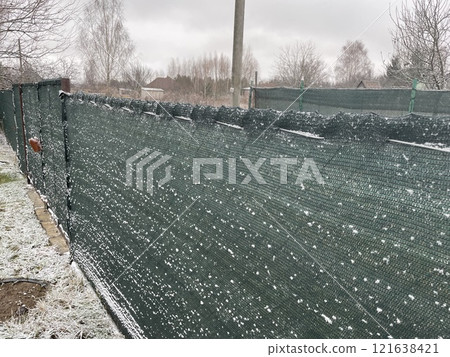 Snow resting gently on a garden fence Snow resting gently on a garden fence 121638421