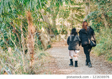 Mother and child walking in winter forest 121638976