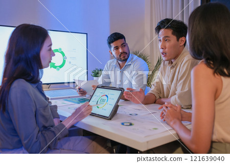 diversity team discusstion about esg and eco friendly system planning in sustainable green office at night diversity team discusstion about esg and eco friendly system planning in sustainable green office at night 121639040