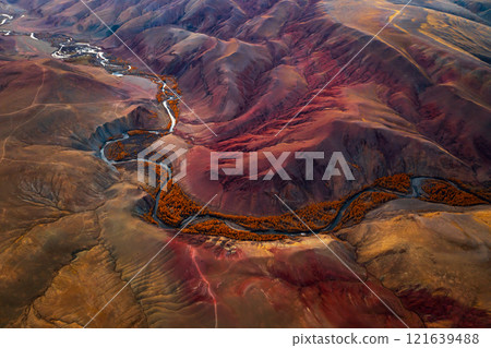 Aerial view of winding river in vibrant red and orange mountain valley 121639488