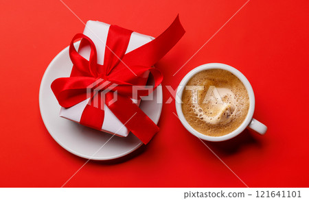 A coffee cup placed alongside a beautifully wrapped Valentine's Day gift box A coffee cup placed alongside a beautifully wrapped Valentine's Day gift box 121641101