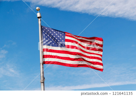 American flag waving against a blue sky 121641135