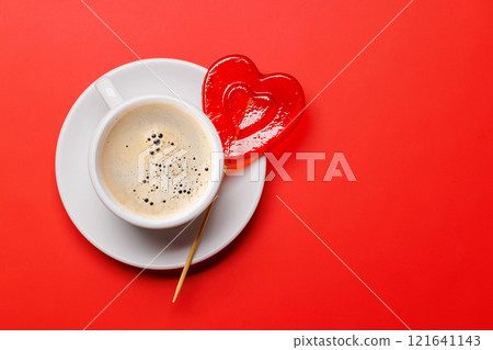 A delightful combination of a steaming coffee cup and a heart-shaped lollipop 121641143