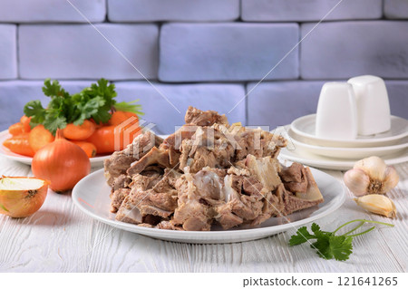 pork and beef bones with leftover meat after cooking broth on a white plate 121641265