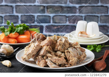 pork and beef bones with leftover meat after cooking broth on a white plate pork and beef bones with leftover meat after cooking broth on a white plate 121641270