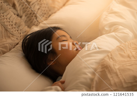 一個孩子睡在有間接照明的房間的床上 一個孩子睡在有間接照明的房間的床上 121641535