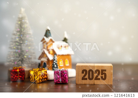 Wooden blocks Hello 2025 near the Christmas tree, gifts and house. Merry Christmas and Happy New Year! Xmas concept. Festive winter holiday. Snowfall Wooden blocks Hello 2025 near the Christmas tree, gifts and house. Merry Christmas and Happy New Year! Xmas concept. Festive winter holiday. Snowfall 121641613