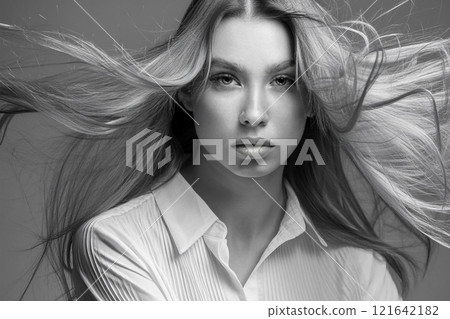 Serene Black and White Portrait of a Windswept Young Woman 121642182
