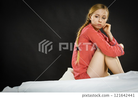 Sad depressed young woman in bed 121642441