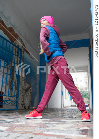 Sporty girl stretching outdoor on city street. Sporty girl stretching outdoor on city street. 121642472