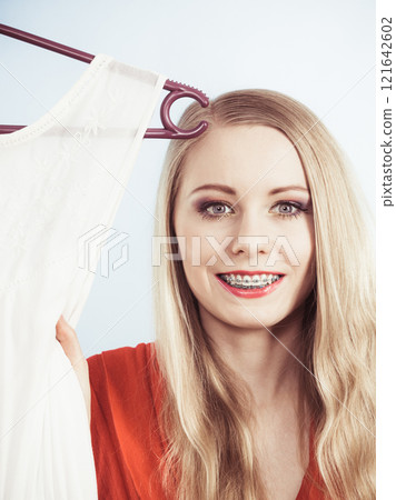 Elegant woman showing her teeth with braces Elegant woman showing her teeth with braces 121642602