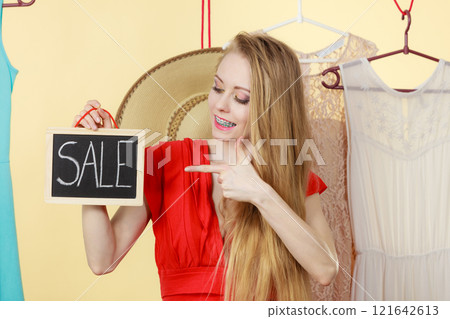 Woman in shop picking clothes, sale concept Woman in shop picking clothes, sale concept 121642613