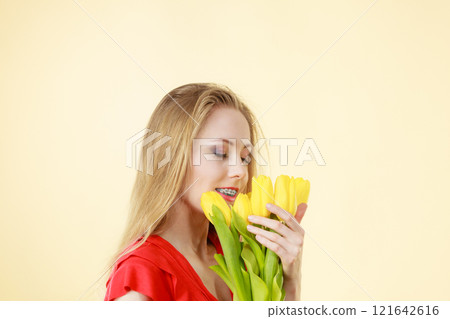 Pretty woman with yellow tulips bunch 121642616