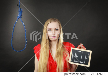 Suicidal woman holding help sign next to rope Suicidal woman holding help sign next to rope 121642618