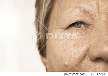 Elderly pensioner female half face portrait closeup 121642781