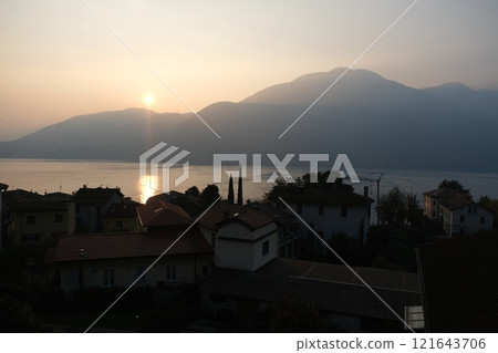 Landscape view of a moored sailing boat reflecting in the lake Como on sunset, 121643706