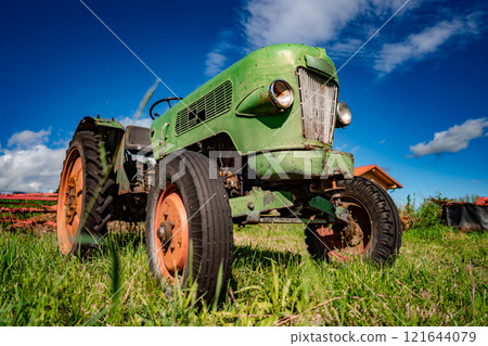Old tractor in the Alpine meadows 121644079