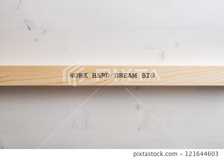 Thin wooden slat with a Work hard Dream big sign on it 121644603