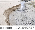 Sandy beach eroded by flowing water 121645737