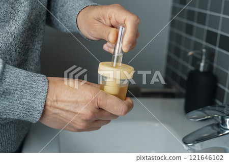 caucasian man fills a tube with a urine sample caucasian man fills a tube with a urine sample 121646102