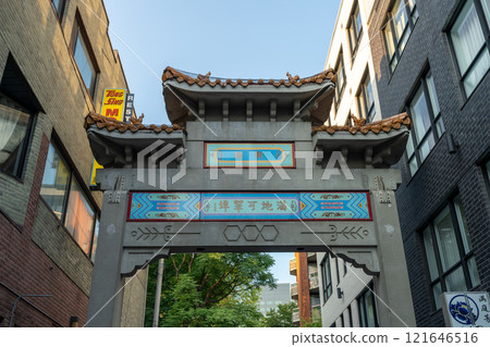 Montreal, Quebec, Canada - August 11 2021 : Street view of Montreal's Chinatown. Paifang Gate of Chinatown on De la Gauchetiere Street. Montreal, Quebec, Canada - August 11 2021 : Street view of Montreal's Chinatown. Paifang Gate of Chinatown on De la Gauchetiere Street. 121646516